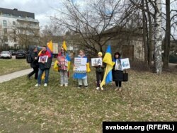 Людзі са сьцягамі Ўкраіны і Інгерманляндыі з плякатамі