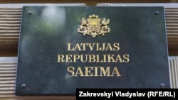 Шыльда на будынку парлямэнту Латвіі.