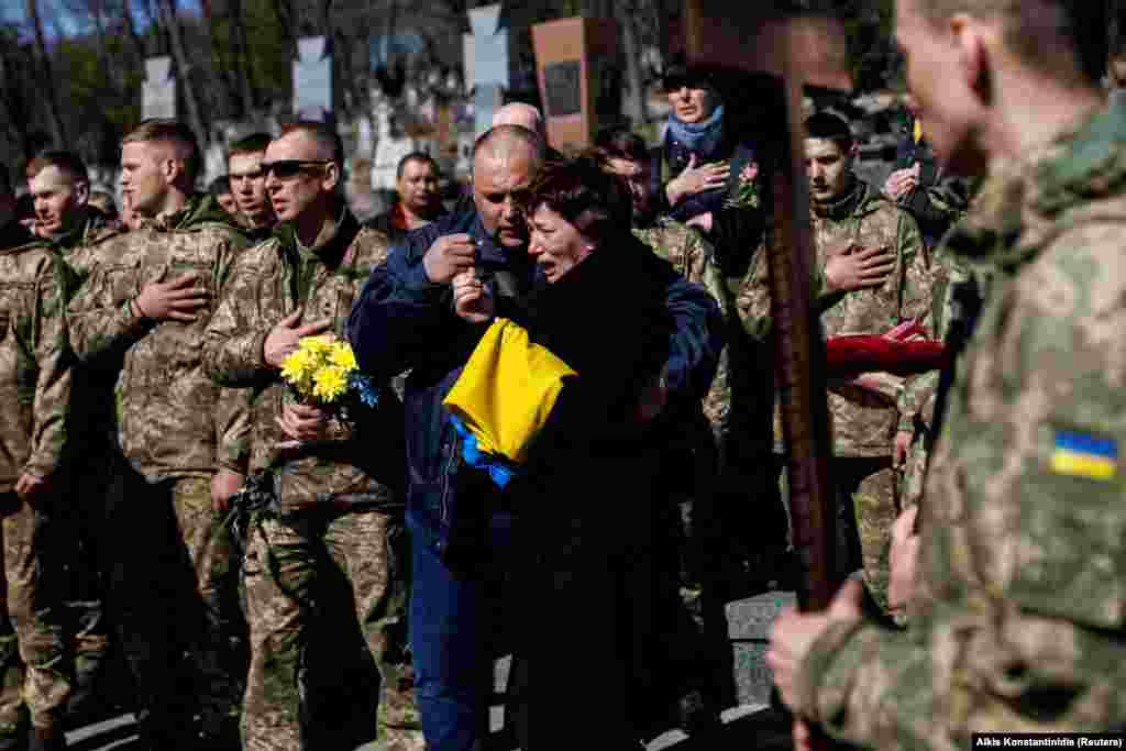 Маці загінулага старшага лейтэнанта Паўла Чэрнікава плача падчас выкананьня вайскоўцамі гімну Ўкраіны на могілках у Львове 28 сакавіка 2022 году