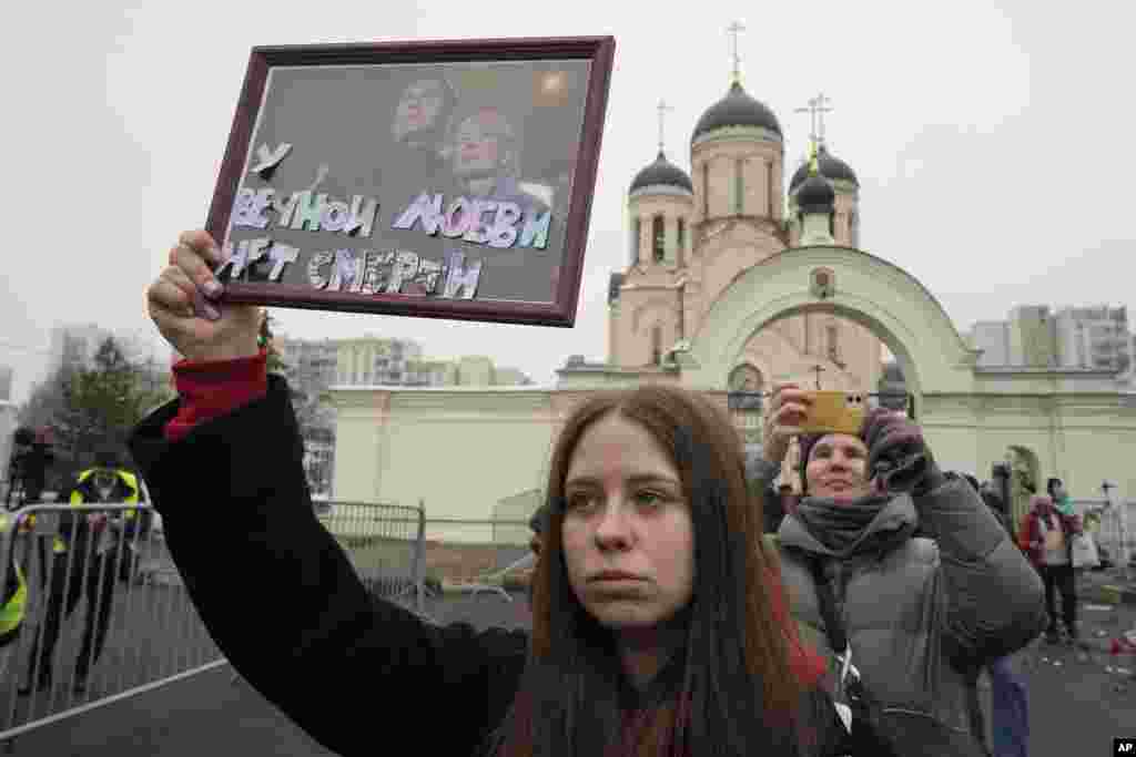 Дзяўчына трымае партрэт Аляксея Навальнага і ягонай жонкі Юліі з подпісам &laquo;У вечнага каханьня няма сьмерці&raquo;, 1 сакавіка 2024 году