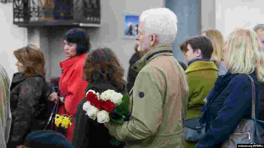 Алесь Бяляцкі трымае букет бел-чырвона-белых ружаў