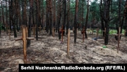 Масавыя пахаваньні ў лесе каля Ізюму, магілы забітых расейцамі жыхароў, верасень 2022