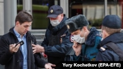 RUSSIA -- Russian police officers stop a man for allegedly breaking self-isolation rules in Moscow, April 9, 2020