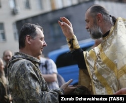 Праваслаўны сьвятар у Данецку бласлаўляе аднаго зь лідэраў прарасейскіх сэпаратыстаў Ігара Стралкова, 2014 год