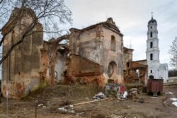 Уніяцкая сьвятыня са сьмецьцем пад сьценамі і адрамантаваная званіца праваслаўнага манастыра